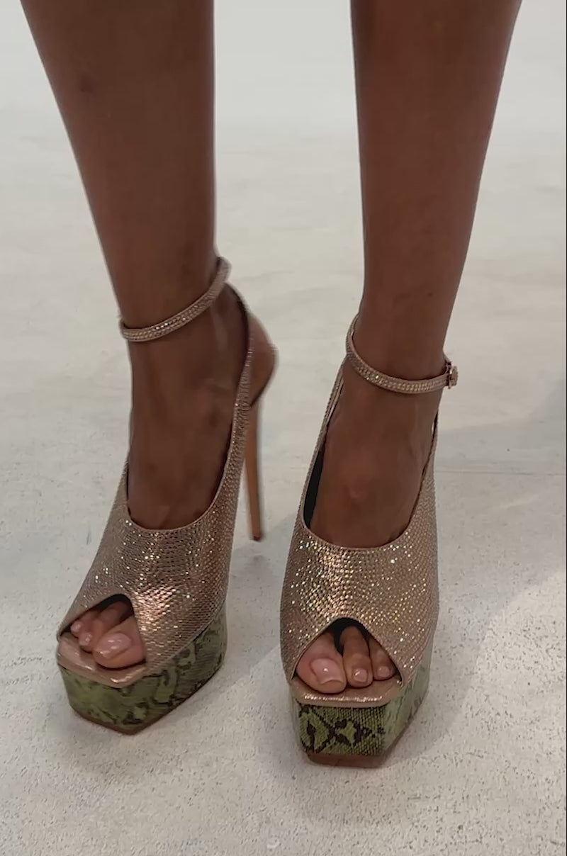 Video of woman modeling the AZALEA WANG MILAGROS MULTI PLATFORM SNAKE AND RHINESTONE SANDAL—with glittering rhinestones, green snake-print platforms, and ankle straps