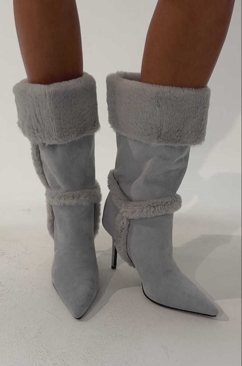 Video of a woman modeling the AZALEA WANG DROWSY BLUE STILETTO BOOT, featuring light blue suede and faux fur trim. 