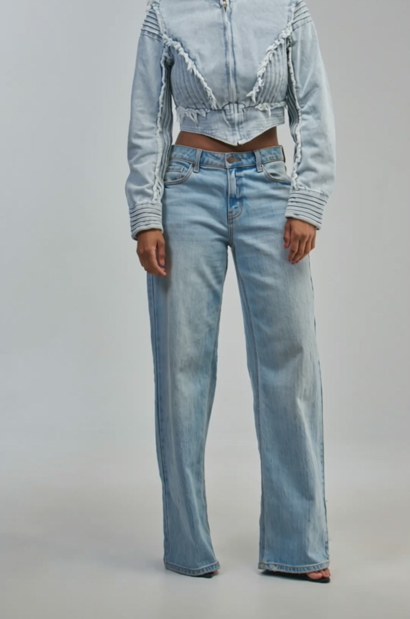Video of a woman modeling the IRIS DENIM MOTO—a light blue cropped moto jacket with pleated and frayed details.