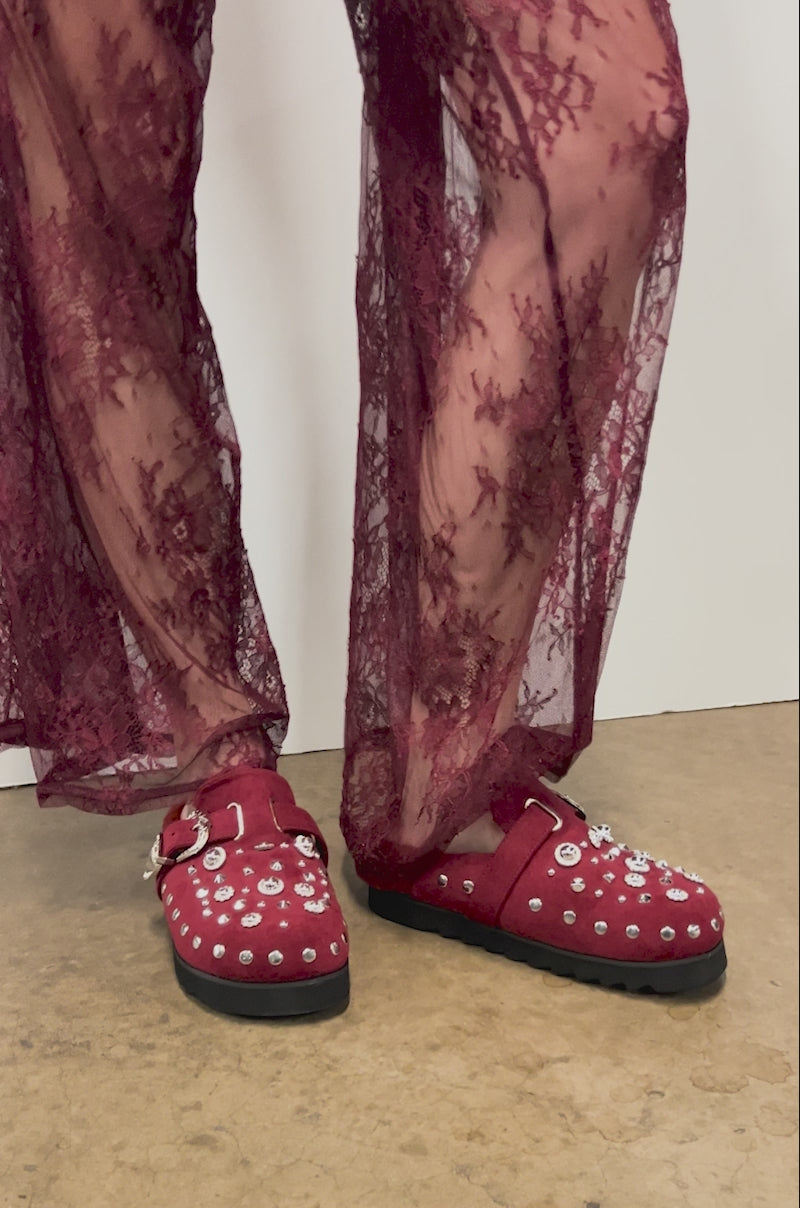 Close-up video of a person wearing sheer, burgundy lace pants and AZALEA WANG CHATTER BURGUNDY FUR SLIP ON CLOGS with faux suede and silver studs.