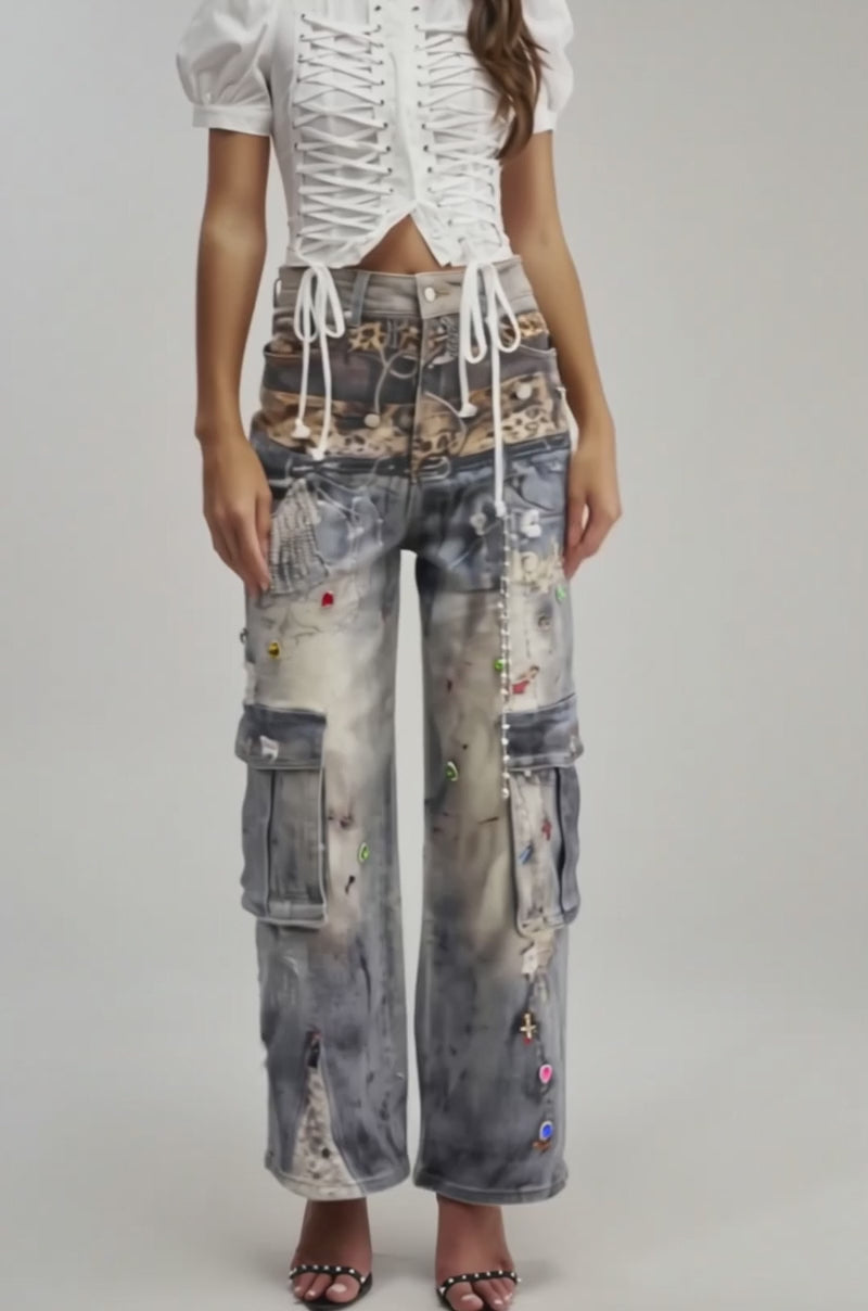 A video of a person wearing COME AND GET IT RELAXED DENIM—high-waisted, wide-leg cargo jeans with distressed details, colorful embellishments, animal print patches, and side pockets—paired with black high-heeled sandals.