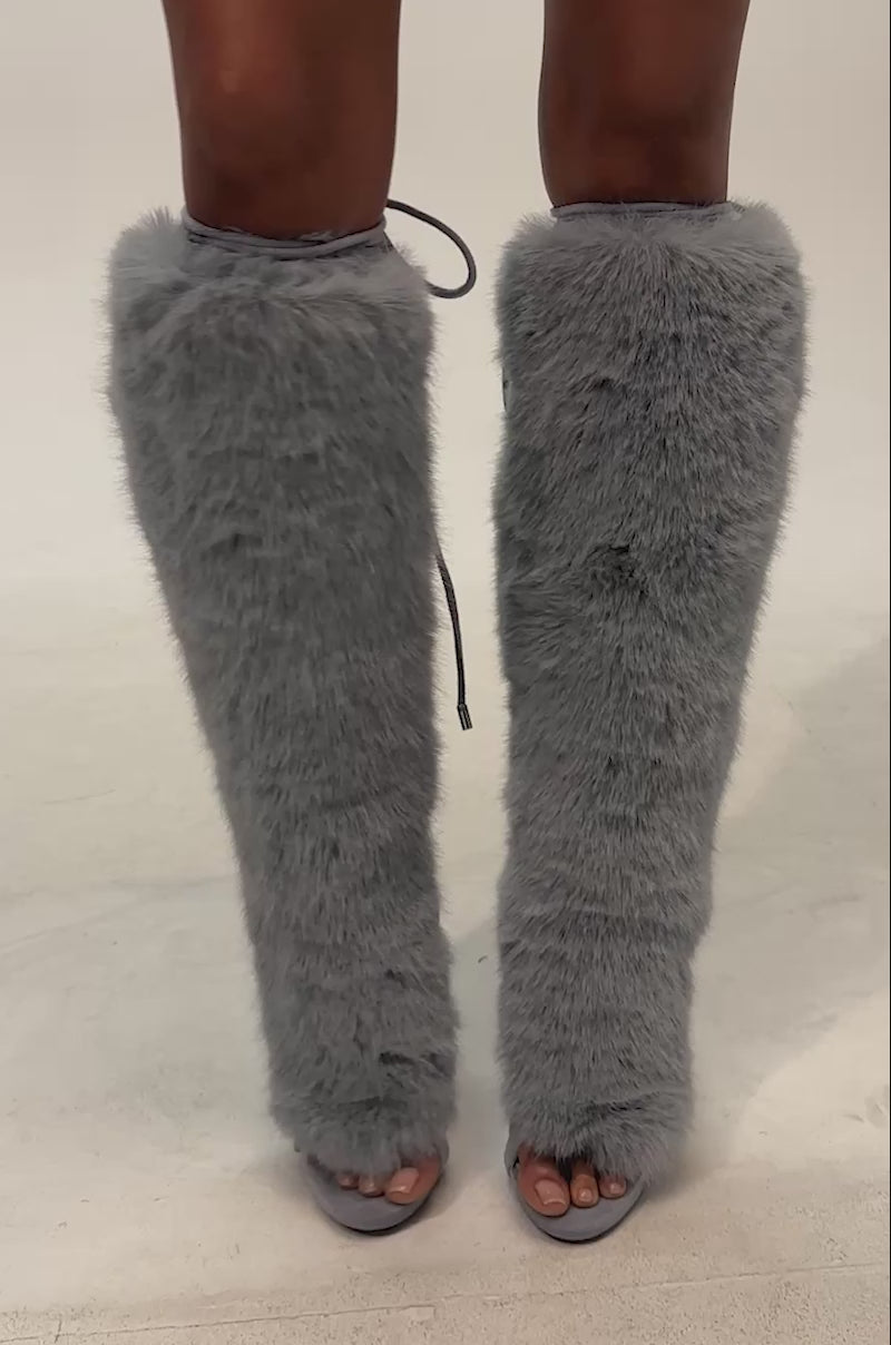 Video of woman modeling the AZALEA WANG STAMOS Dusty Blue Stiletto Sandal with fur—featuring tall, fluffy trim, open toes, and lace-up details