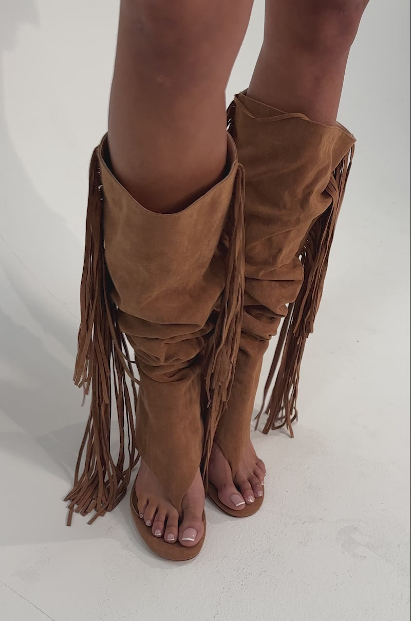 A video of a woman wearing the AZALEA WANG JOHANNA Tan Fringe Gladiator Sandal with open toes against a plain background.