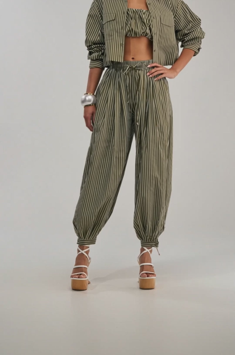 A video of a woman in the COULD BE DIFF BALLOON PANT, styled with a matching striped cropped top and jacket. 