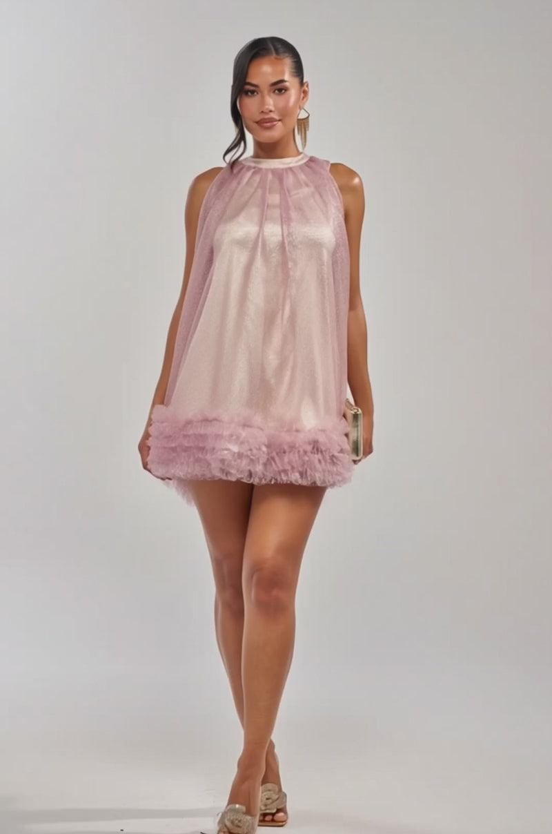 Video of woman modeling the ARI TULLE RUFFLE MINI DRESS IN LIGHT PINK, featuring a sheer overlay and ruffled hem. 