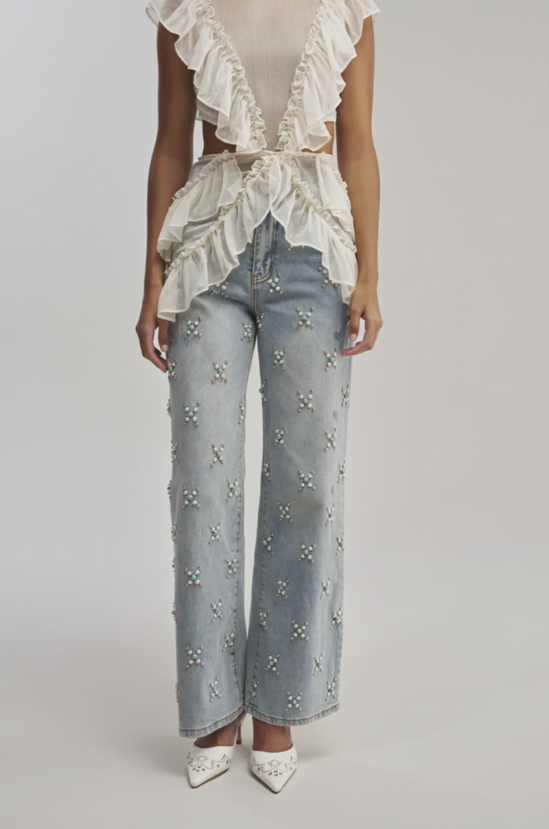 Video of a woman modeling the DRIFT AWAY BLOUSE—a sheer chiffon ruffle cutout top with open sides.