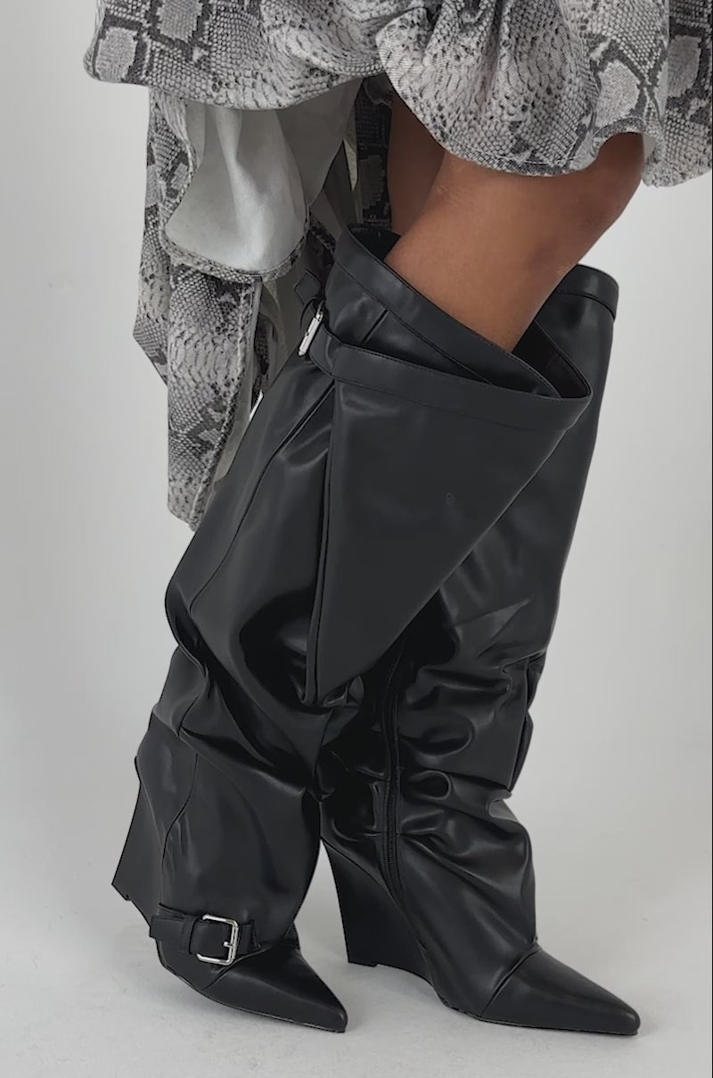 Video of a woman modeling the AZALEA WANG ARACELI BLACK BELTED DETAIL WEDGE BOOTS.