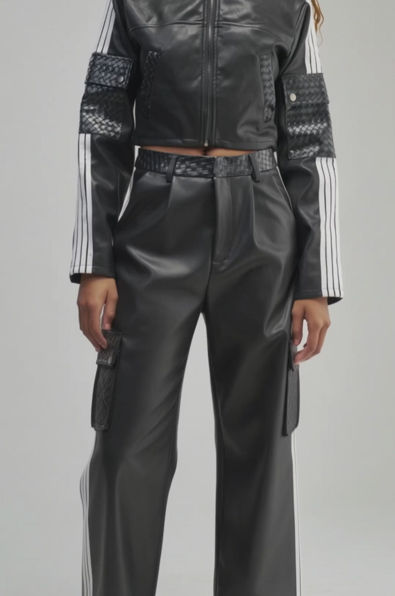 Video of a woman modeling the DONT TEST ME FAUX LEATHER BOMBER—a black faux leather jacket with white stripes on the sleeves.