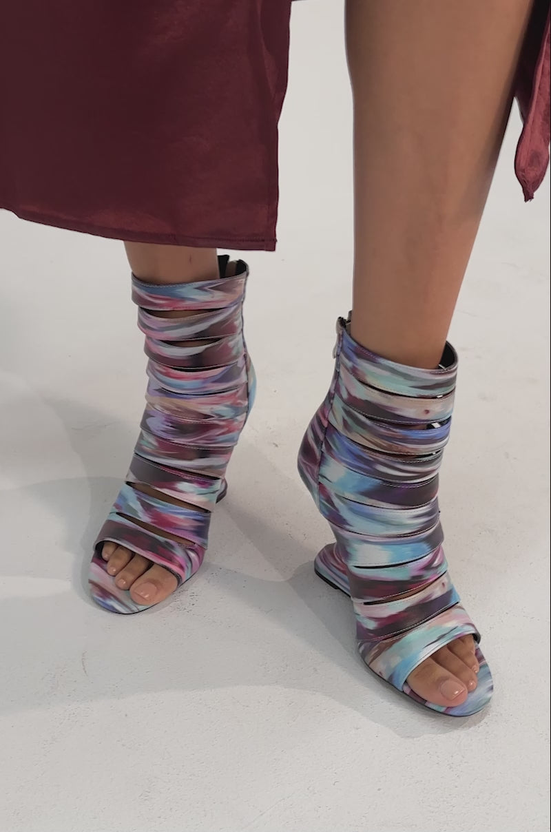 A video of a person wearing the AZALEA WANG JOHANNES MULTI RAINBOW WEDGE OPEN TOE BOOTIE.