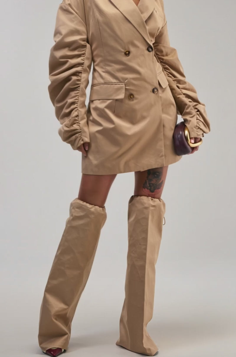 Video of a woman modeling the BUSINESS MEETING CHIC BLAZER DRESS AND LEG WARMER SET IN TRENCH.