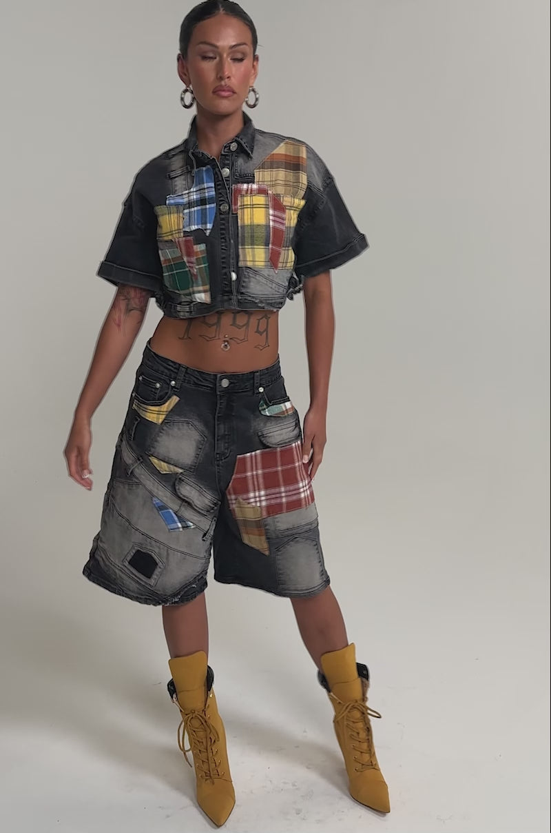 Video of woman modeling the DREA MIXED PLAID CROP SHORT SLEEVE BUTTON DOWN with hoop earrings, slicked-back hair, and a confident look against a plain background.