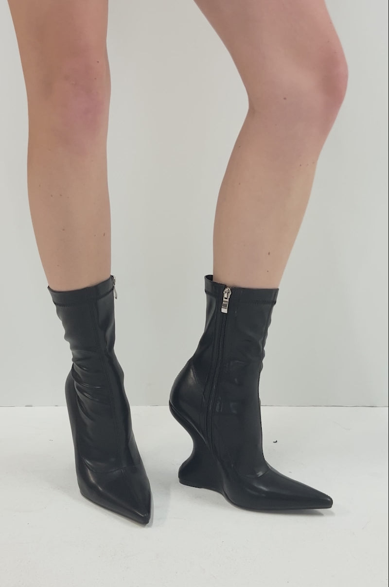 Video of person showcasing the AZALEA WANG DAMAN BLACK PU WEDGE BOOTIE with a pointed toe and side zipper, standing against a plain white background, with only their lower legs visible.