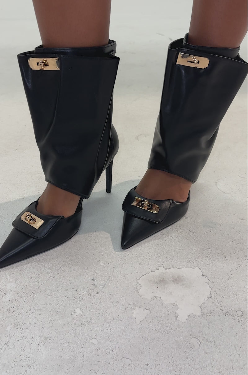 A video of a person in a leopard print skirt and AZALEA WANG SARVESH BLACK CUTOUT STILETTO BOOTIE stands confidently on a light background.