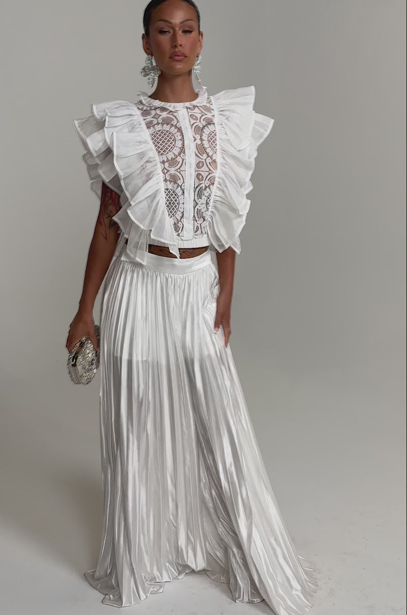 A video of a woman in the CALLED OUT SATIN PLEATED PALAZZO PANT IN WHITE, featuring wide-leg satin pleats. 