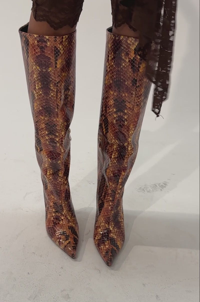 Video of a woman modeling the AZALEA WANG SIMONE ORANGE SNAKE STILETTO BOOTS.