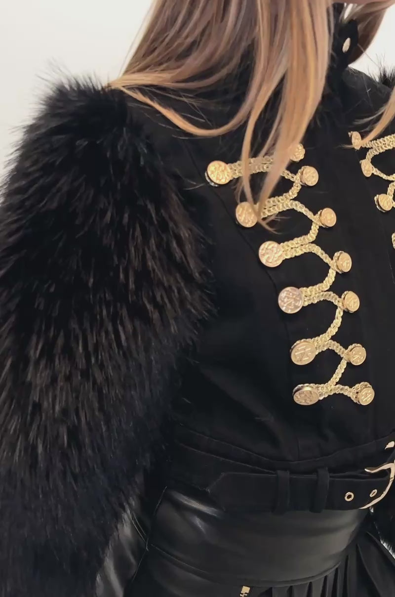 Video of a woman modeling the SCARLETT FUR TRIM DENIM JACKET—a military-inspired black denim jacket adorned with gold detailing and faux fur sleeves. 
