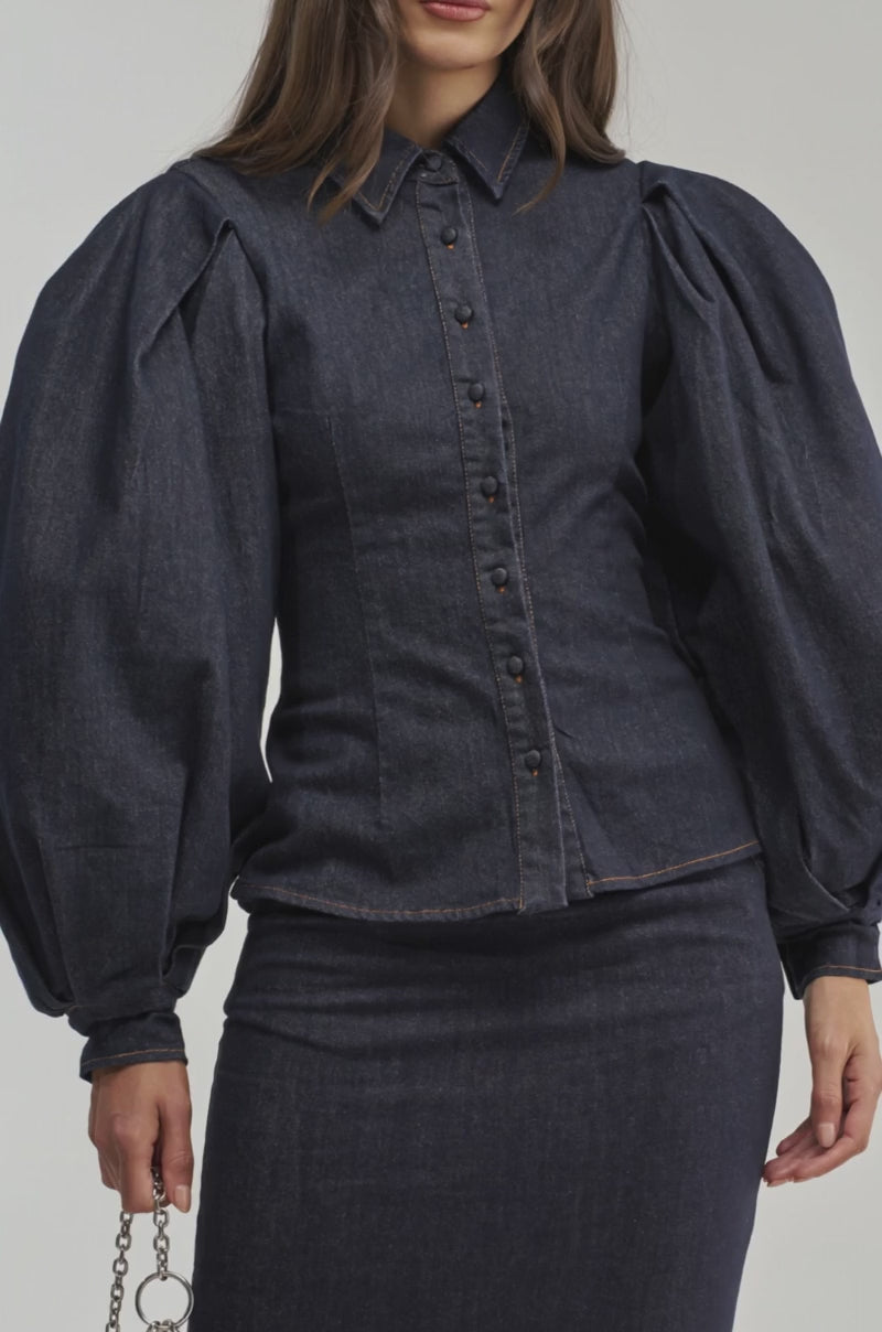 Video of a woman modeling the LET'S CHANGE IT UP DENIM BLOUSE with bold balloon sleeves.