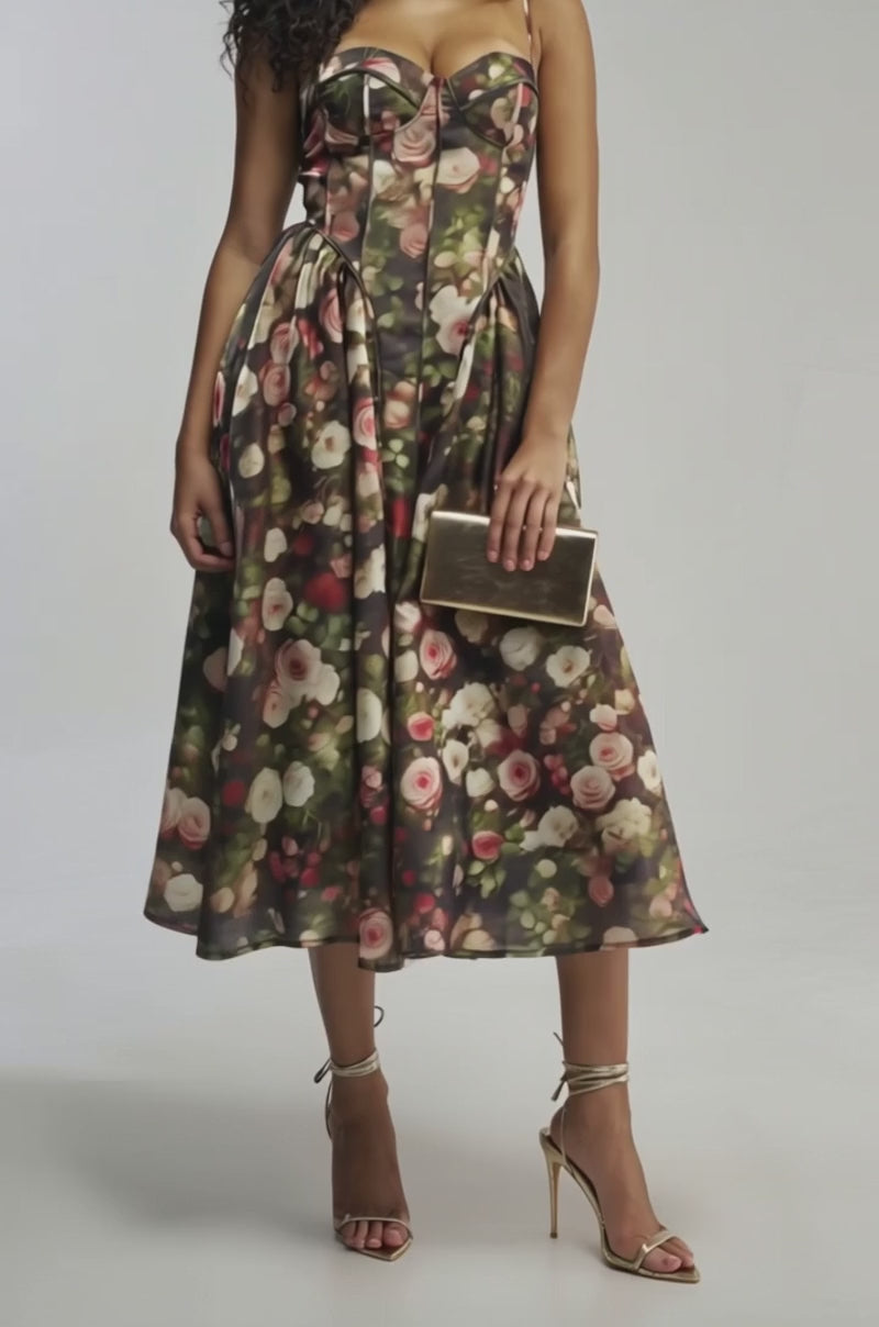 Video of woman modeling the FEELING FLORAL MAXI DRESS IN GREEN MULTI— featuring a fitted bodice and vibrant rose print. She completes her elegant wedding guest look with a gold clutch and strappy gold heels.