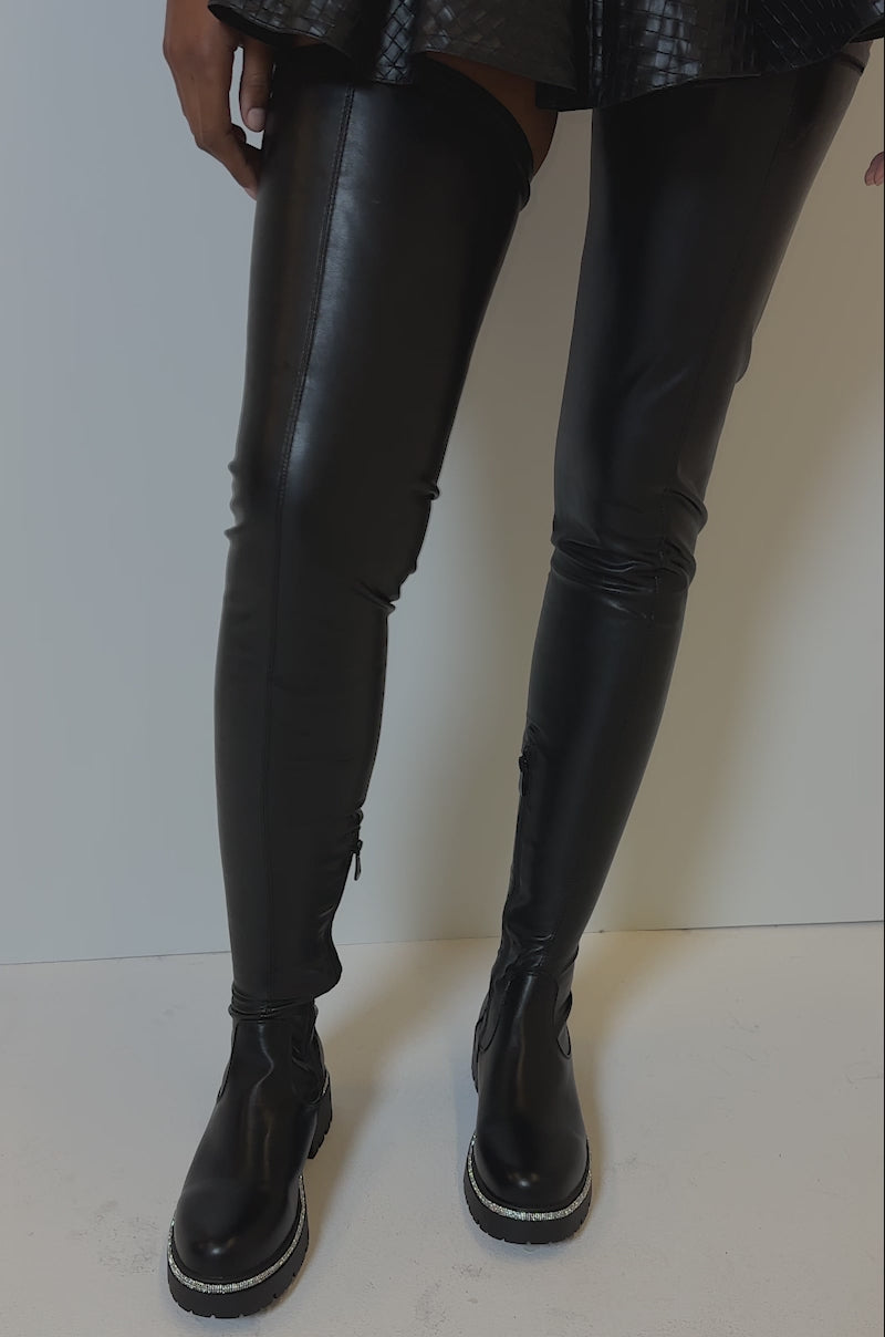 Video of person modeling the AZALEA WANG NEW RULES THIGH HIGH STRETCH BOOT WITH 4 WAY STRETCH IN BLACK, featuring a sleek, shiny finish and flatform sole. 