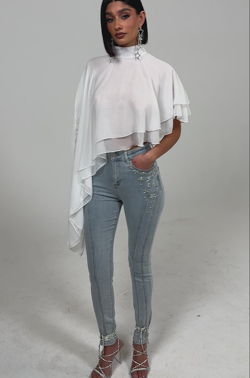 Video of woman modeling the FOLLOW ME DRAPEY BLOUSE, featuring white chiffon fabric, a mock neckline, and a flowy silhouette.