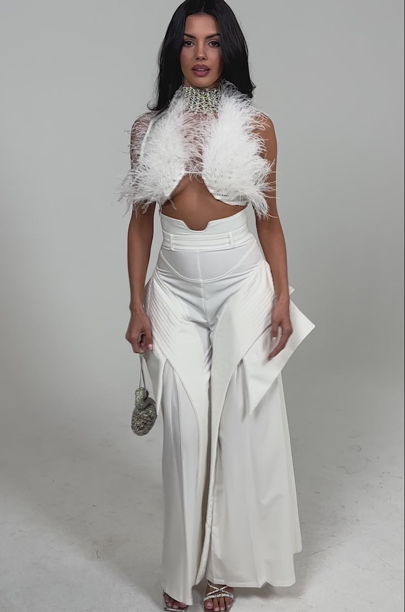 Video of woman modeling the TOO COOL FOR YOU TROUSER. She holds a small silver round purse and wears open-toed heels, standing out against a light background.