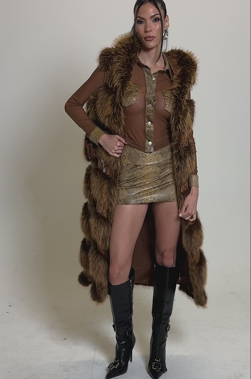 Video of woman modeling the GOOD OMEN FUR TRIM VEST over a brown outfit and black buckle knee-high boots.