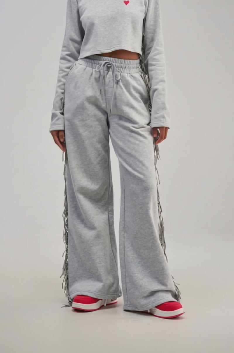 Video of a woman modeling the PLAYING CARDS WIDE LEG JOGGER IN HEATHER GREY paired with a gray crop top. 