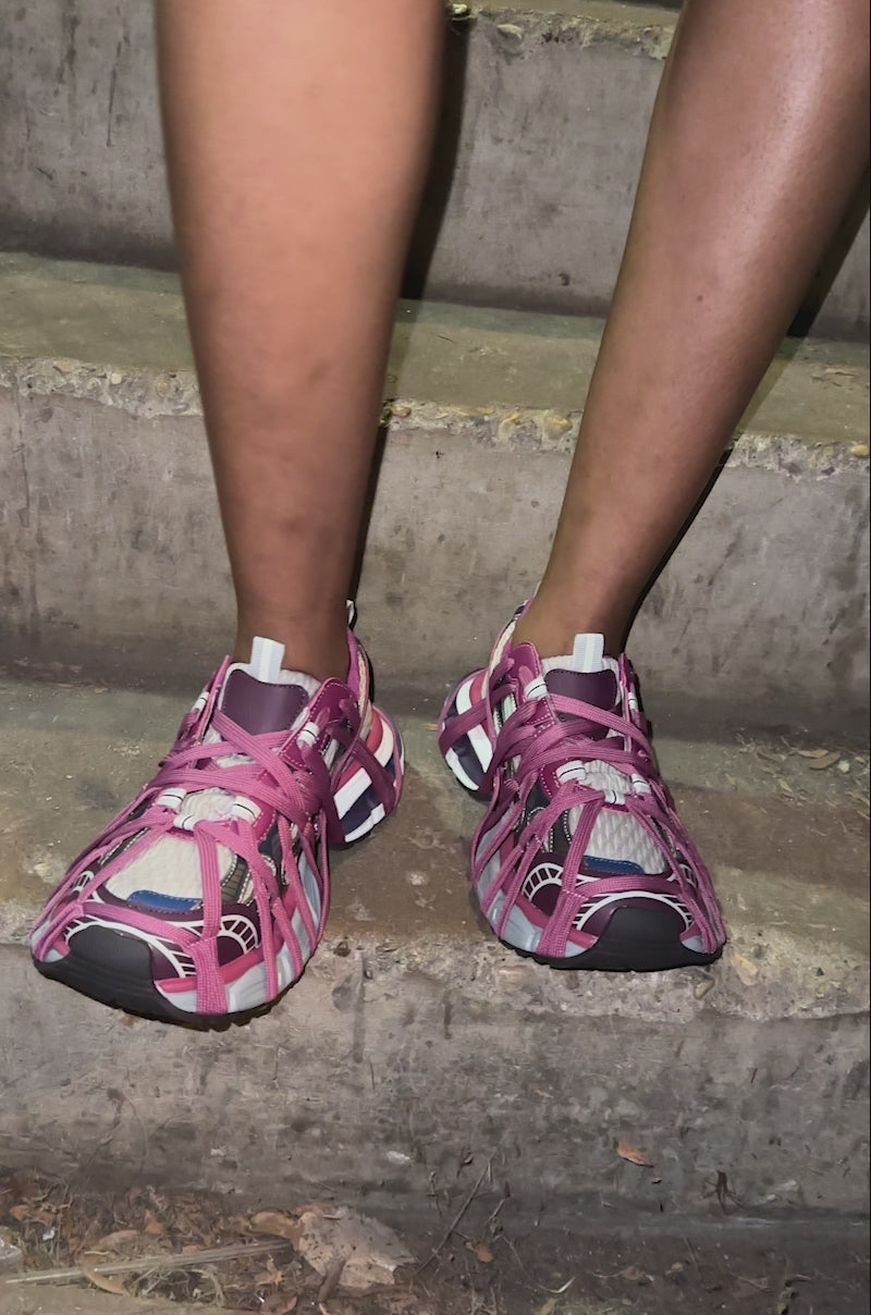 A video of a person wearing the AZALEA WANG SELIE PURPLE LACE UP SNEAKER stands on concrete steps, with only their legs showing.