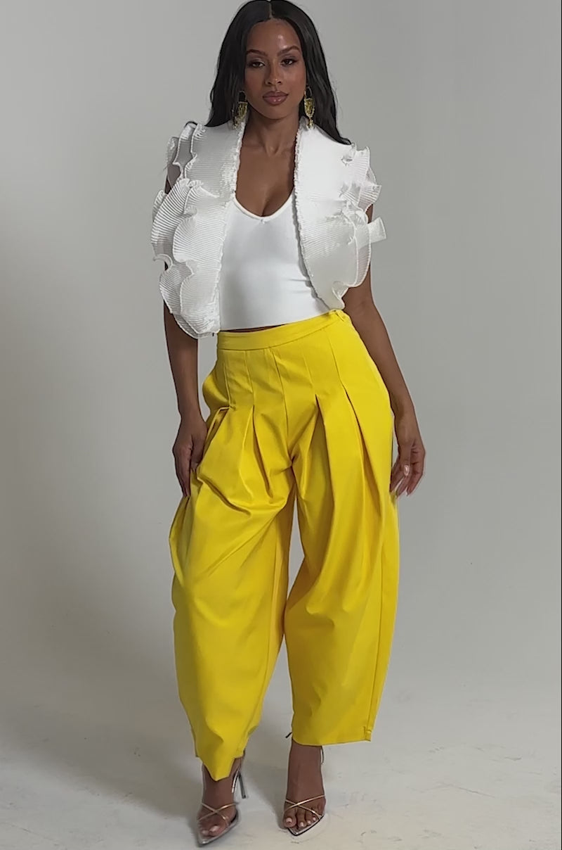Video of woman modeling the BRING IT ON TROUSER with pleats, and strappy high-heeled sandals against a plain background.