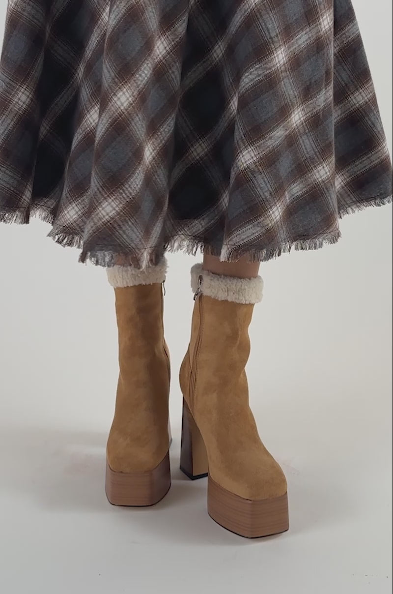 Video of a woman modeling the AZALEA WANG LAROUSSE Camel Faux Suede Shearling Block Bootie, featuring tan suede and cream shearling trim.