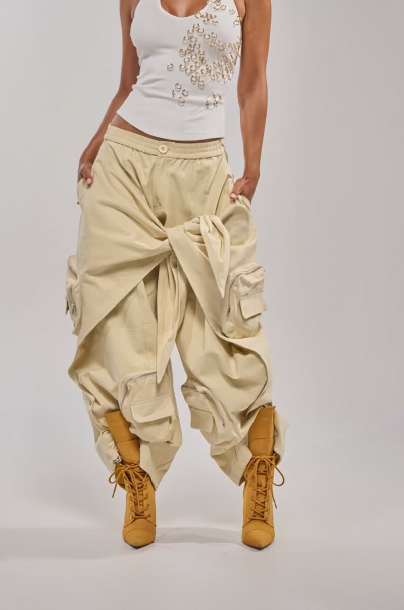 Video of woman modeling the DO THE MOST TIE FRONT PANT—khaki cargo pants with an oversized front tie—embracing utility style against a plain light background.