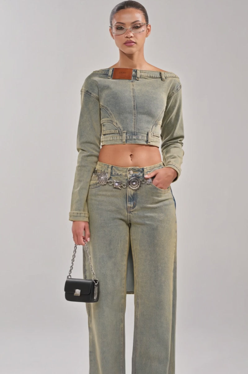 Video of woman modeling the BIG STEPPER DENIM BLOUSE with a high-waisted denim skirt, glasses, and silver handbag, styled with streetwear vibes against a plain light background.