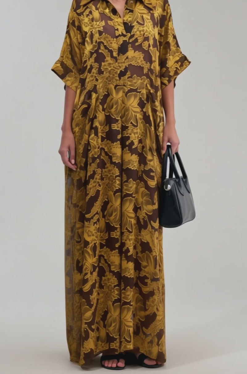 A video of a woman wearing the DEEP IN THE FEELS LACE JUMPSUIT IN YELLOW MULTI, featuring a loose fit and vibrant floral pattern with short sleeves and a collar. 