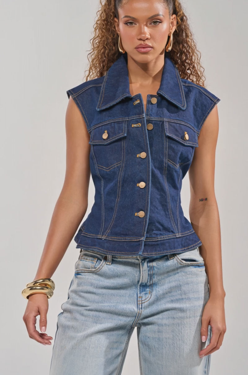 Video of woman modeling the BIRDIE DENIM VEST with gold buttons, and light blue jeans as she poses confidently against a plain background.