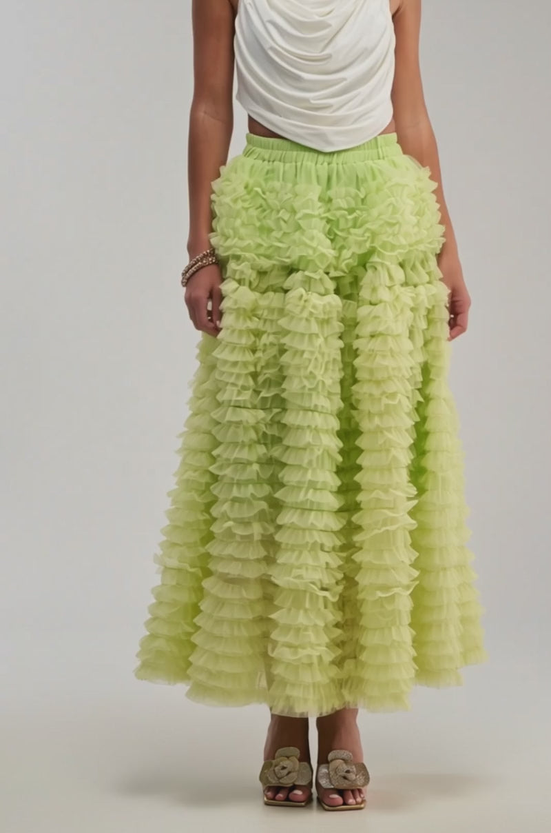 A video of a model wearing the LOVE THE DRAMA MESH MAXI SKIRT in lime green with gold open-toe shoes.