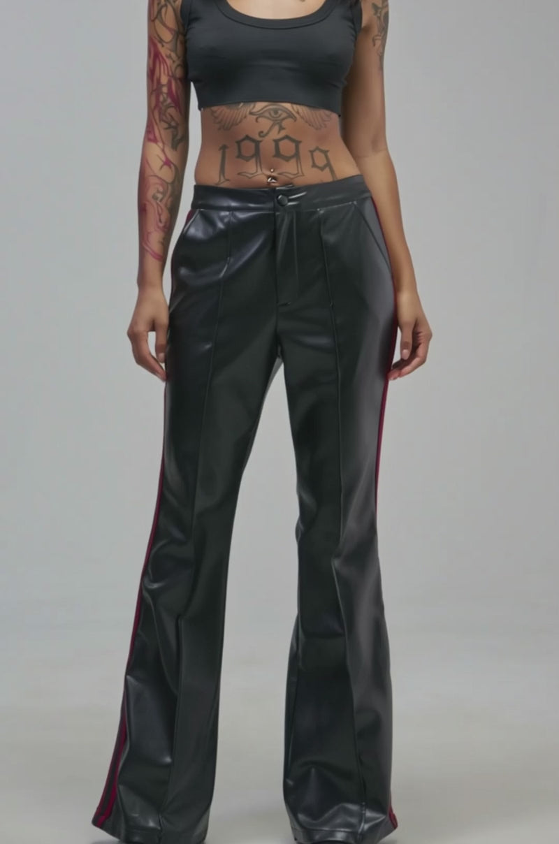 Video of a woman modeling the COME AND GET IT TROUSER with black faux leather, red side stripes, and flared legs.