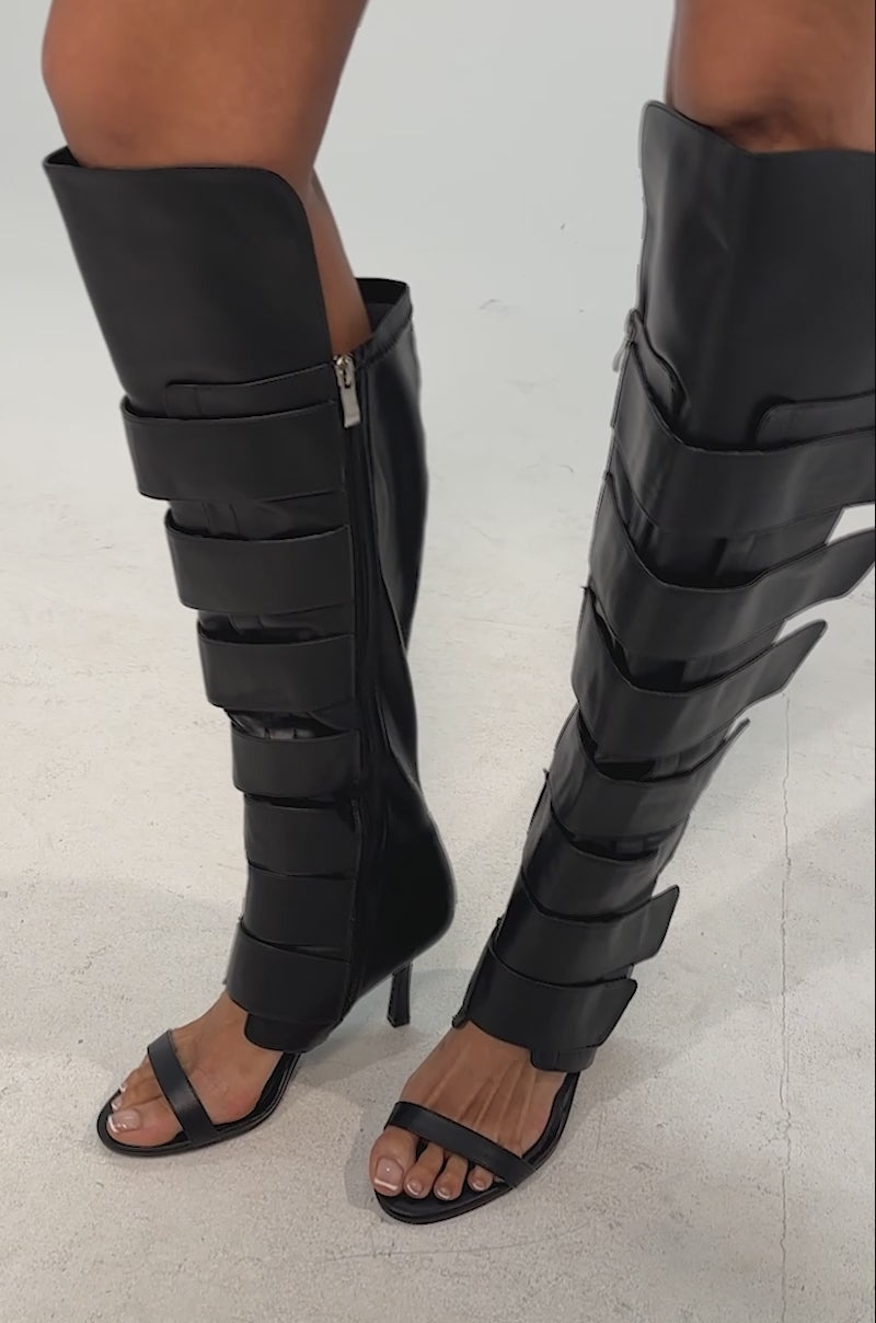 Video of woman modeling the AZALEA WANG NOIRWAVE BLACK PU STILETTON SANDAL BOOT—chic, knee-high faux leather stiletto boots with open toes that elevate the stylish look.