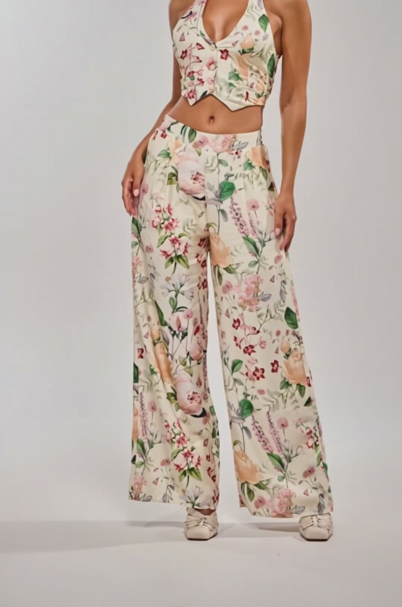 Video of woman modeling the LADY B TROUSER, a high-rise, wide-leg floral pant paired with a matching sleeveless halter crop top.