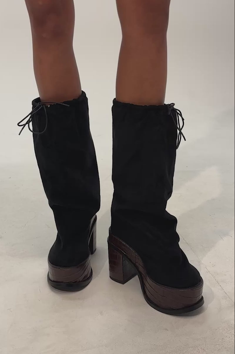 Video of woman modeling the AZALEA WANG LESLIE BLACK CROC PLATFORM SLOUCHY BOOT, featuring chunky brown textured heels and a croc-embossed finish