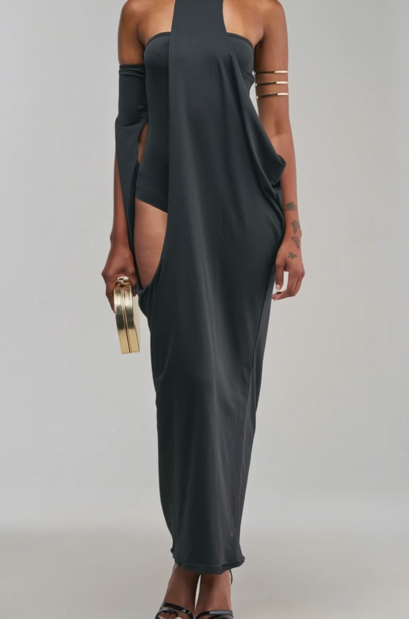 Video of a woman modeling the OPTICAL ILLUSION MAXI DRESS IN BLACK—a unique cutout halter maxi dress with off-the-shoulder sleeves.
