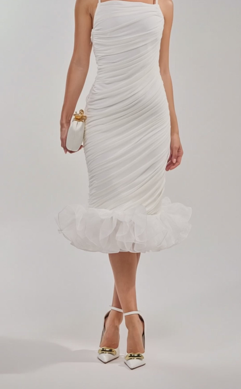 A video of a woman wearing the NATALIA CHIFFON RUFFLE MIDI DRESS, a white ruched bodycon with spaghetti straps and a ruffled hem.