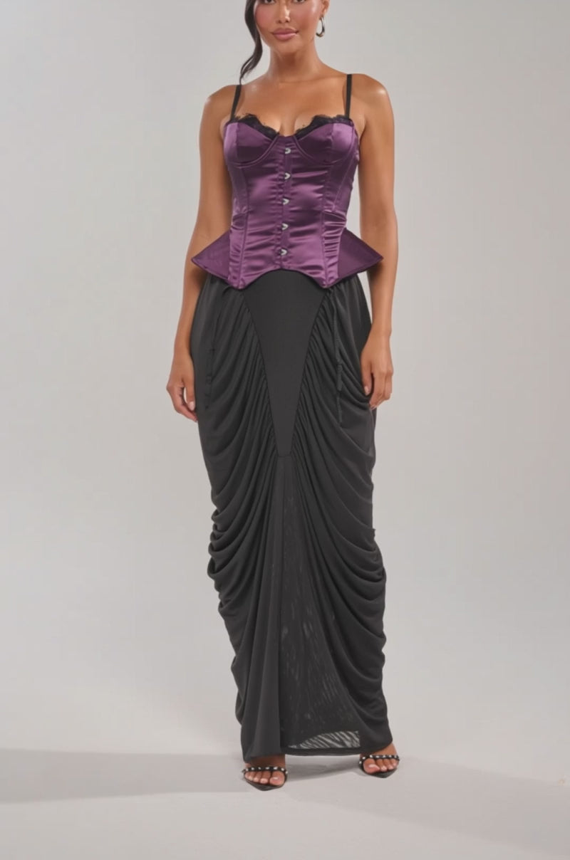 Video of woman modeling the FLY ME OUT SATIN CORSET in purple with black lace trim and a black ruched skirt, set against a plain light background.