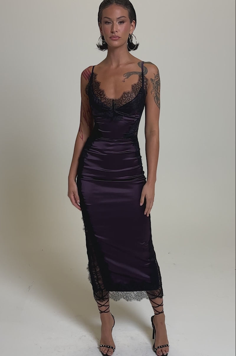 A video of a woman in strappy black heels, wearing the ESSENTIAL LACE TRIM SATIN SLEEVELESS MAXI DRESS with spaghetti straps and lace trim, set against a plain light gray background.