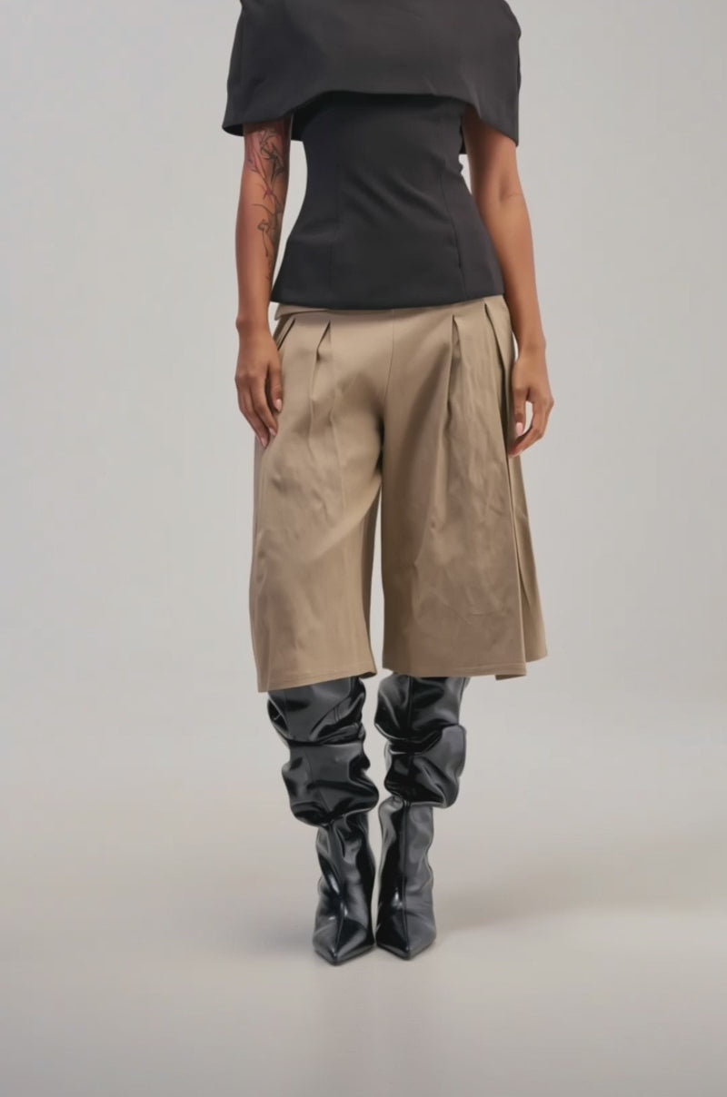 Video of a woman modeling the DOTTIE BERMUDA SHORT—tan, pleated, and wide-leg with a folded waistband.