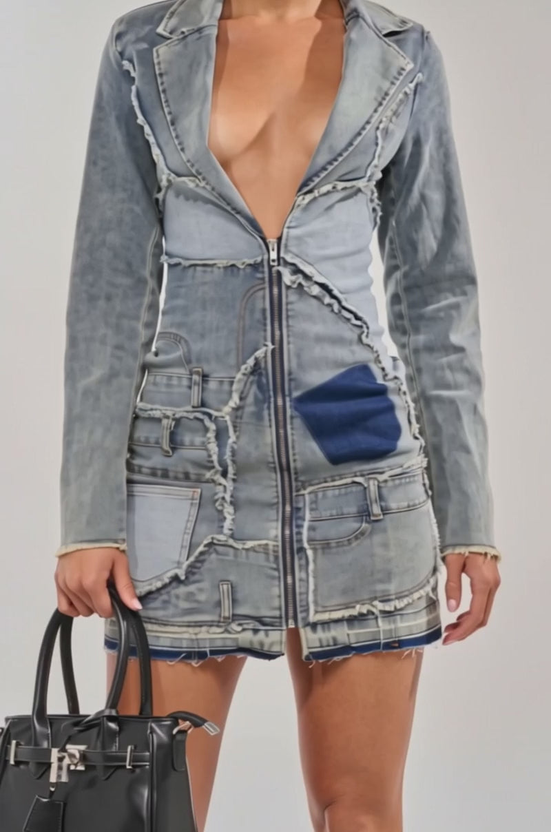 A video of a woman in the BURNING BLUE BLAZER DENIM MINI DRESS with a deep V-neckline, holding a black handbag.