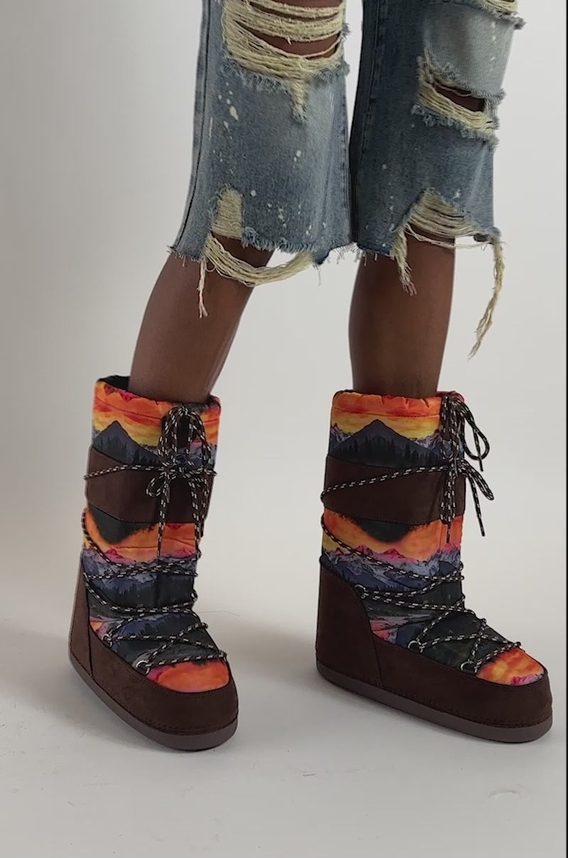 Video of a woman modeling the AZALEA WANG FROSTLING MULTI COLOR PRINT FLAT BOOT, featuring colorful patterns and brown soles.
