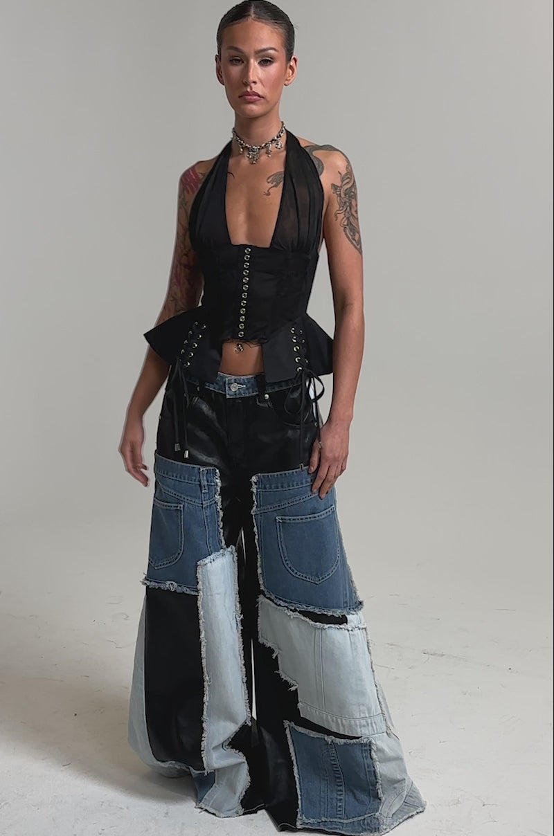 Video of woman modeling the TOO MUCH GOING ON RELAXED DENIM, showcasing visible seams and frayed edges, embodying street style against a plain light background.