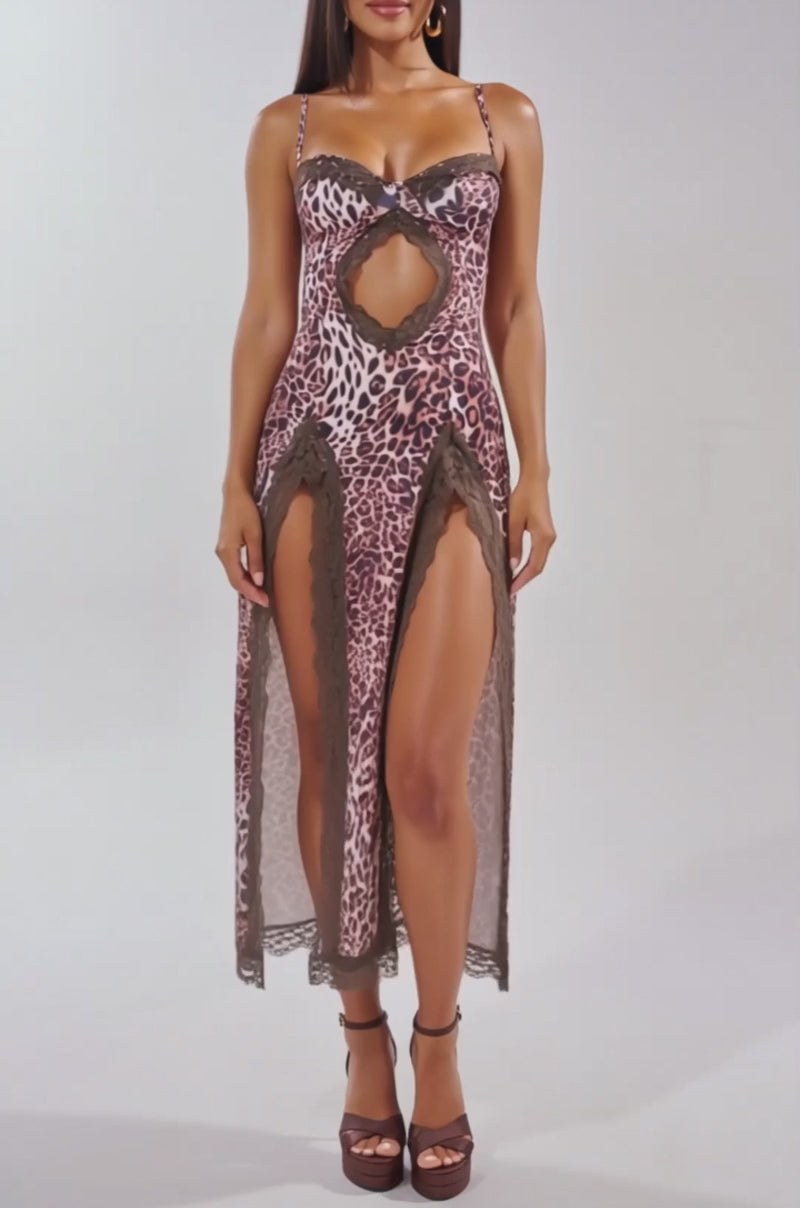 Video of woman modeling the SWEET DREAMS LACE MAXI DRESS IN CHEETAH, featuring cut-outs, high slits, and lace trim. Paired with hoop earrings and heeled sandals