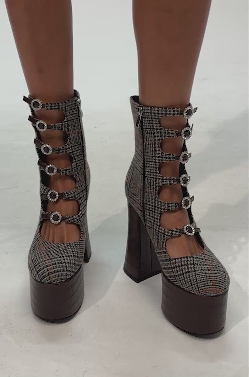 Video of woman modeling the AZALEA WANG VIVIENNEA BROWN PLAID platform pump—featuring a high heel, brown croc faux leather accents, and five oval cutouts with buckles—the perfect statement shoes for your next date night.