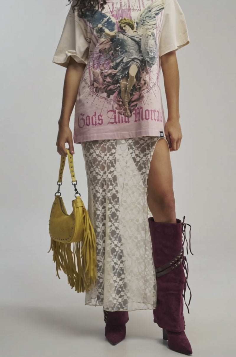 Video of woman modeling the FIRST ROW HEAVEN SENT CHAOS GRAPHIC TEE, a beige oversized streetwear t-shirt featuring an angel, a shield, and “Gods And Mortals” text. 